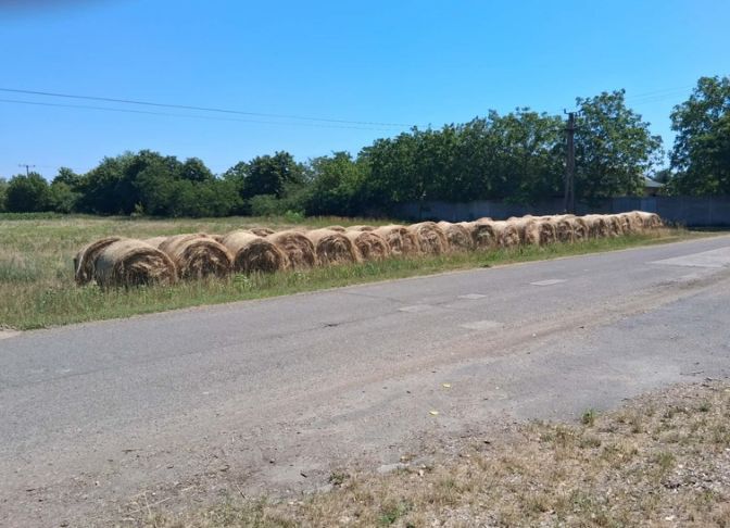 A képen az eladásra kínált szénabálák sora látható.