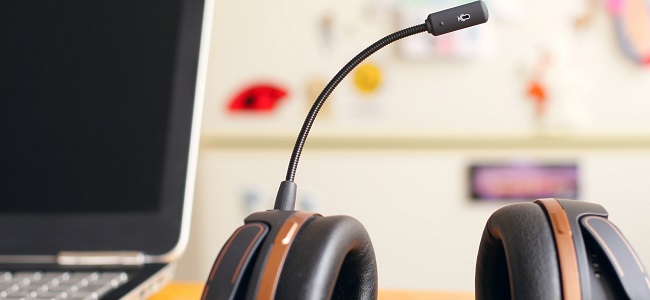 A képen egy ügyfélszolgálati irodabelső látható a háttérben, előtérben egy headset-tel.