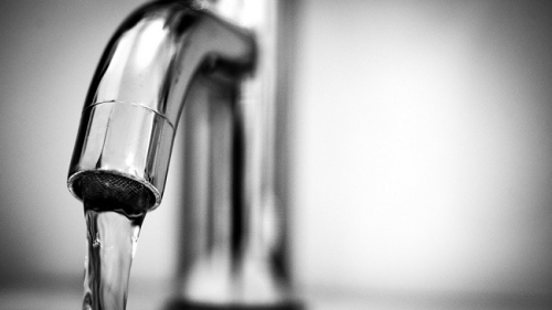 The image is an illustration showing water flowing from a bathroom faucet.